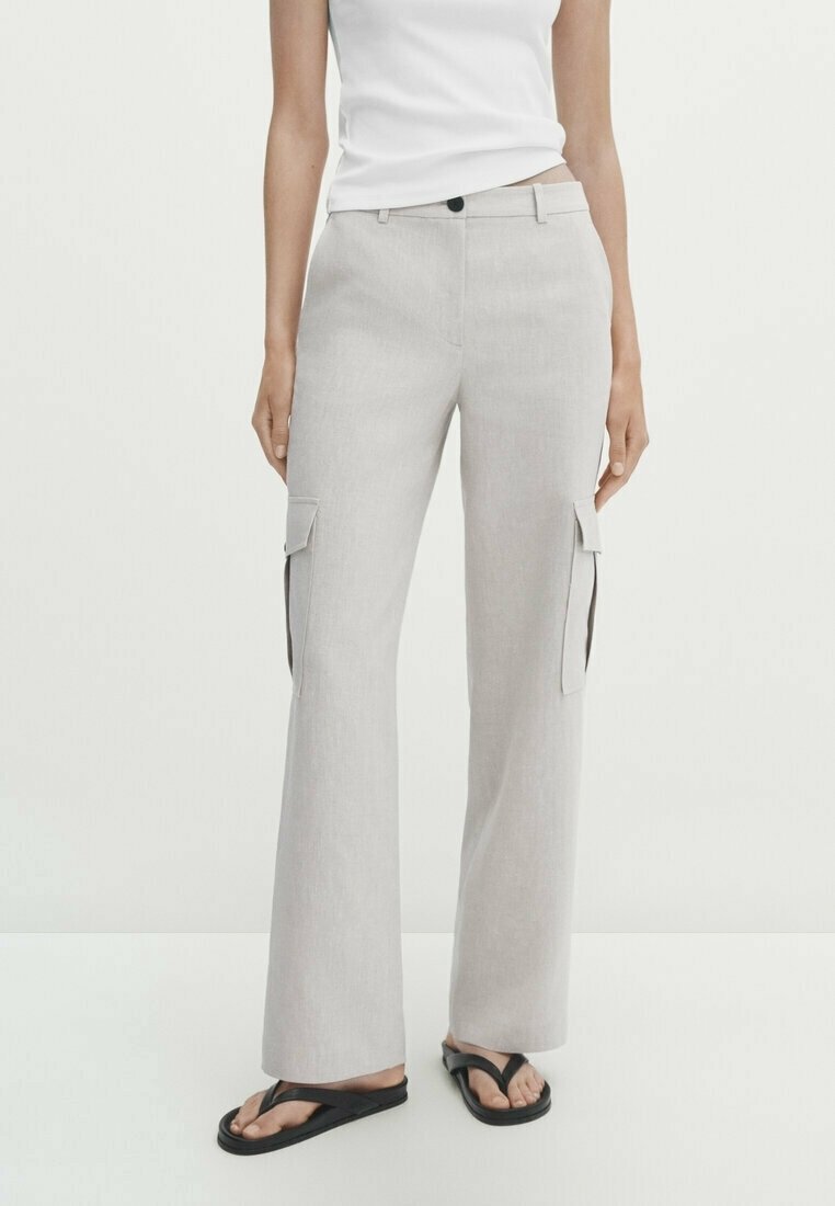 Lichtgrijze cargobroek met een recht figuur, zijzakken en een gladde textuur, gedragen met zwarte flip-flops en een wit tanktop.