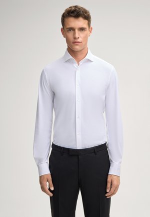 Chemise blanche à manches longues en tissu lisse avec un col boutonné, présentant un col classique et une silhouette ajustée.