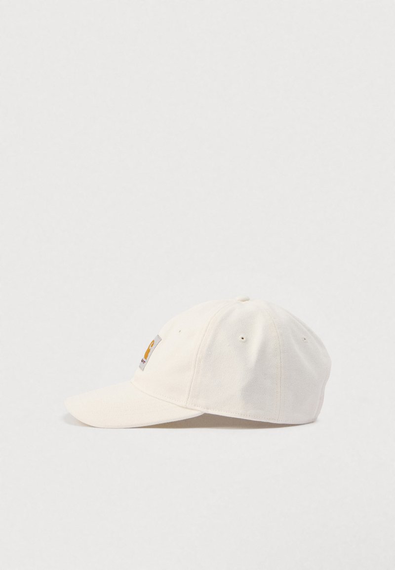 Cappellino da baseball in cotone color bianco sporco con visiera curva e una piccola toppa quadrata con logo sul pannello frontale.