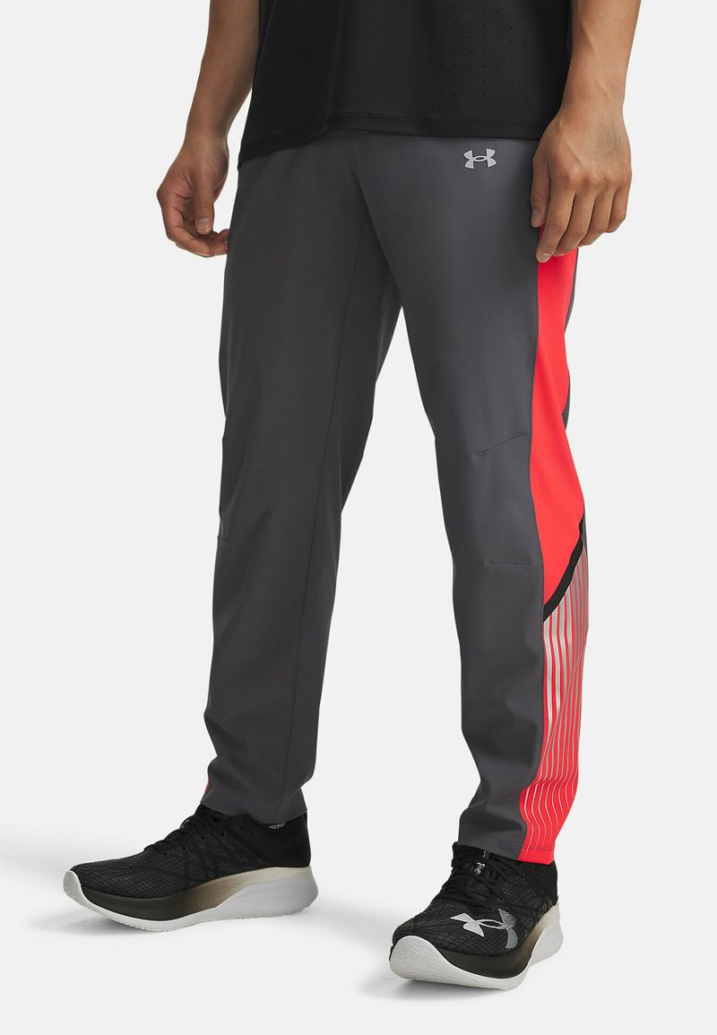 Athletic pants in gray with a red side panel and striped accents. Made of lightweight material. Features a logo on the hip and pockets.