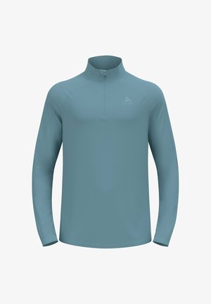 Light blue athletic half-zip long-sleeve top made from smooth, stretch fabric. Features a high collar and subtle logo detail on the chest.