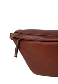 Brun læderfanny pack med en glat tekstur, rund form, lynlåslukning og messingdetaljer. Har en kontrasterende sort stikning.