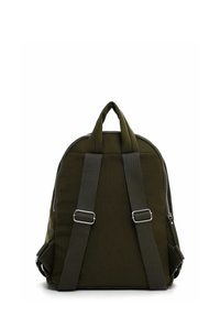 Tmavě zelený polstrovaný batoh s nastavitelnými černými ramenními popruhy a dvojitými rukojeťmi na bílém pozadí.