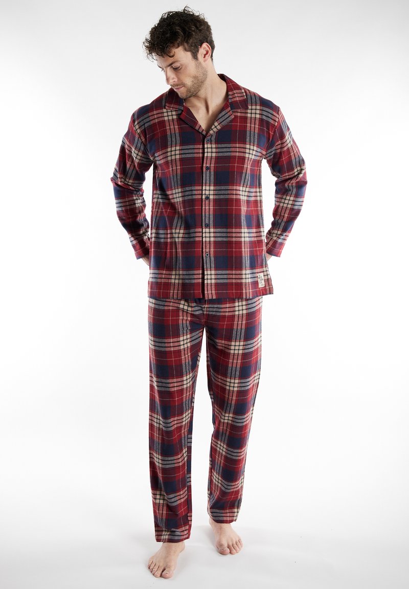 Geruite flanellen pyjama's in rood, marineblauw en crème; lange mouwen met knopen aan de bovenkant en bijpassende broek met een comfortabele pasvorm en rechte pijpen.