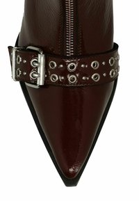 Bordeaux leren enkellaars met een spitse neus, zilveren gespband met metalen oogjes en een rits aan de zijkant.