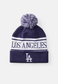 Tamno plava pletena kapa s bijelom prugom na kojoj piše "LOS ANGELES" i bijelim "LA" logom. Ima pahuljastu pom-pom lopticu na vrhu.