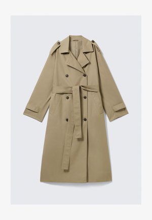 Trench-coat beige longueur genou avec boutons croisés, ceinture, épaulettes et brides aux poignets, posé à plat sur fond blanc.