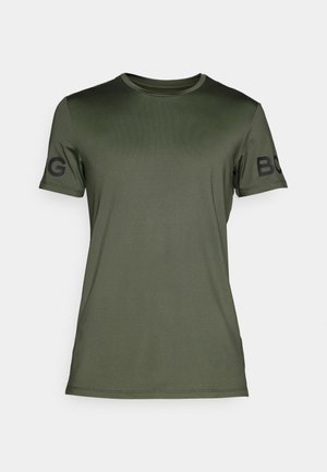 T-shirt à manches courtes olive en tissu lisse. Présente un col rond et une inscription en lettres noires sur la manche gauche.
