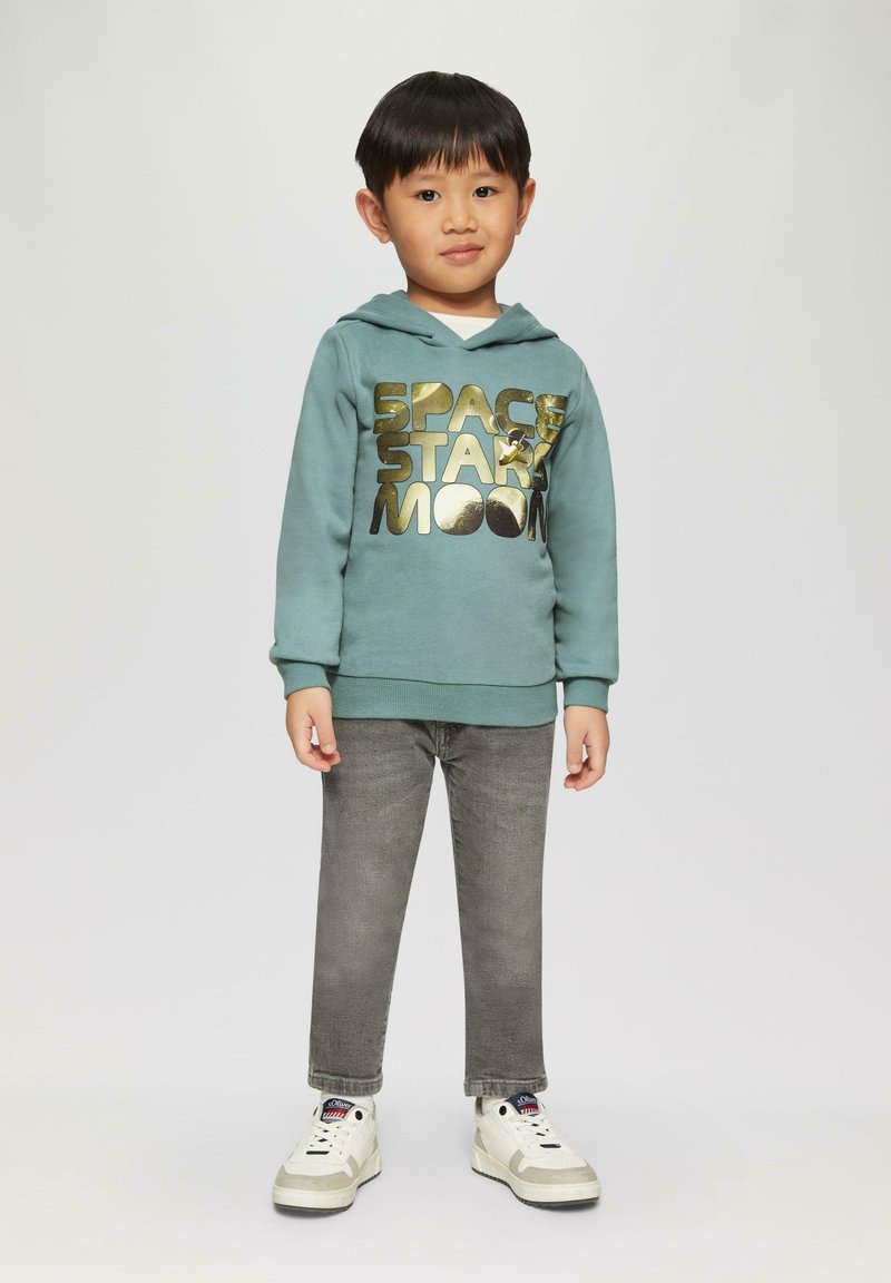 Turquoise hoodie met gouden bedrukt tekst "SPACE STAR MOON," gecombineerd met grijze jeans en witte sneakers met grijze accenten.