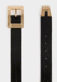 Cintura in pelle nera testurizzata con grande fibbia rettangolare dorata caratterizzata da un design embosso lineare, mostrata distesa con fibbia e fori visibili.