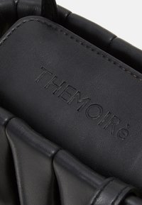 Borsa a tracolla in pelle nera con finitura testurizzata, lati plissettati e logo in rilievo "THEMOIRé" sul pannello superiore.