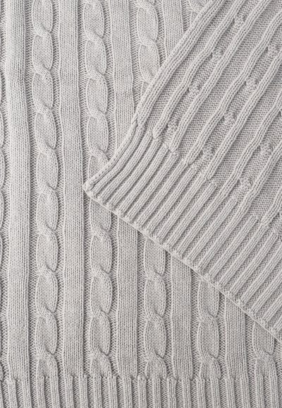 Υφαντό ύφασμα ανοιχτό γκρι πουλόβερ με κάθετα σχέδια πλέξης σε σχήμα καλωδίου και ριμπ, εμφανίζοντας μια διπλωμένη μανσέτα με λεπτομέρειες ριμπ.