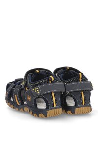 Sandalias azul marino con acentos amarillos, que cuentan con un diseño transpirable, correa ajustable de Velcro y suela de goma texturizada para mayor agarre.