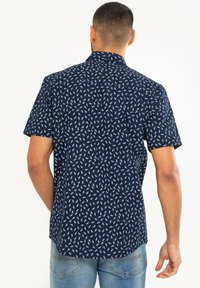 Marineblauw overhemd met korte mouwen met een wit bloemenpatroon, lichtgewicht stof, casual pasvorm en een puntige kraag.