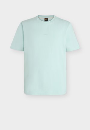 Világoskék rövid ujjú, kerek nyakú póló, amelyen finoman dombornyomott "BOSS" logó látható a mellrészen, fekete gallércímkével.