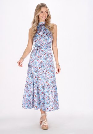 Blares Blumen-Maxikleid mit hohem Kragen und tailliertem Oberteil, das einen gestuften Rock und eine Blende an der Taille aufweist. Getragen mit beigen Plateau-Sandalen.