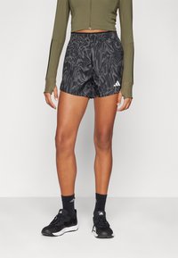 Shorts de sport légers et noirs avec un design texturé et à motifs. Présentent une taille élastique et un accent logo blanc sur le côté.
