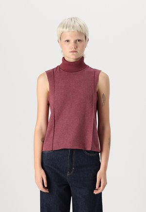 Sleeveless turtleneck top in burgundy knit fabric; features a relaxed fit and side seam details. Worn with dark blue jeans.