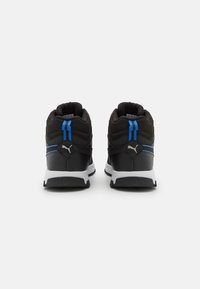 Chaussures de sport noires avec des rayures bleues et des accents blancs, dotées de cols rembourrés et de matériaux texturés pour une bonne adhérence et un soutien.