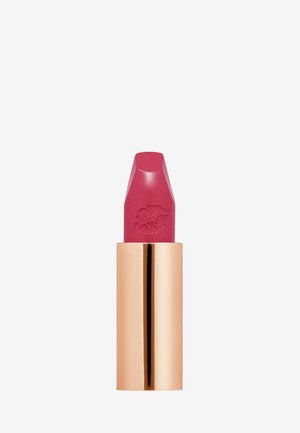 Rossetto rosa in un tubetto metallico dorato con un tappo trasparente. Il bullet ha una punta affilata con un'impronta di foglia, mostrando una texture liscia.