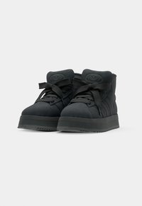 Sorte høyde sneakers laget av semsket skinn med gummisåle, med tykke snøringer og en preget logo på tungen.