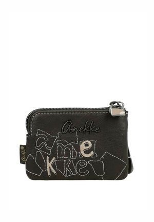 Pequeño monedero de cuero negro con cremallera, letras decorativas cosidas y el nombre de la marca "Anekke" en el frente.