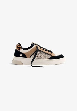 Zapatillas con una parte superior sintética en crema y marrón, panel brillante, acentos de ante negro y un talón con estampado de leopardo. Cordoneras negras y suela de goma.
