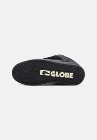 Black rubber skate shoe sole with a patterned texture and prominent "GLOBE" branding in cream-colored letters. Flat design, durable materials.