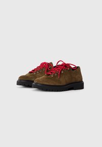 Brown suede hiking shoes with thick black soles and bright red laces, displayed side by side on a plain white background.