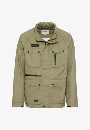 Veste olive avec un col haut, plusieurs poches et des détails zippés. Fabriquée en tissu durable, avec une finition texturée et un logo brodé.