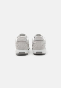 Grå semsket og hvit netting sneakers; polstret krage, teksturert såle og preget logo på hælen. Lav profil design med forsterkede detaljer.