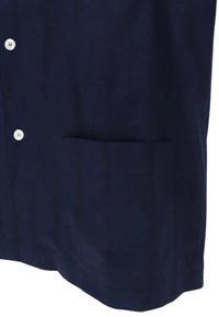 Camicia blu navy in tessuto liscio con chiusura a bottoni, dotata di tasca frontale e fondo dritto. Design semplice senza fantasie.