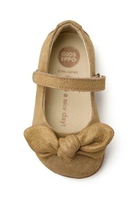 Zapato de ballet de ante marrón con un acento de lazo metálico, cierre con correa y forro interior suave. Logo de la marca visible en la plantilla.