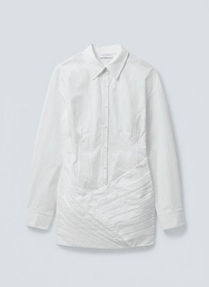Λευκό πουκάμισο με μακριά μανίκια, κουμπιά και μυτερό γιακά, με διαγώνια πιέτα στο κάτω μπροστινό μέρος.