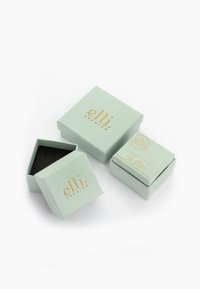 Square, mint green jewelry boxes with gold branding. One box is open, revealing a black interior. Compact and flat design, high-quality paper.
