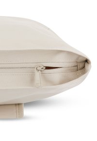 Beige szövet táska cipzárral, melynek texturált felszíne és YKK cipzár húzója van. Lekerekített szélek, lapos alj.