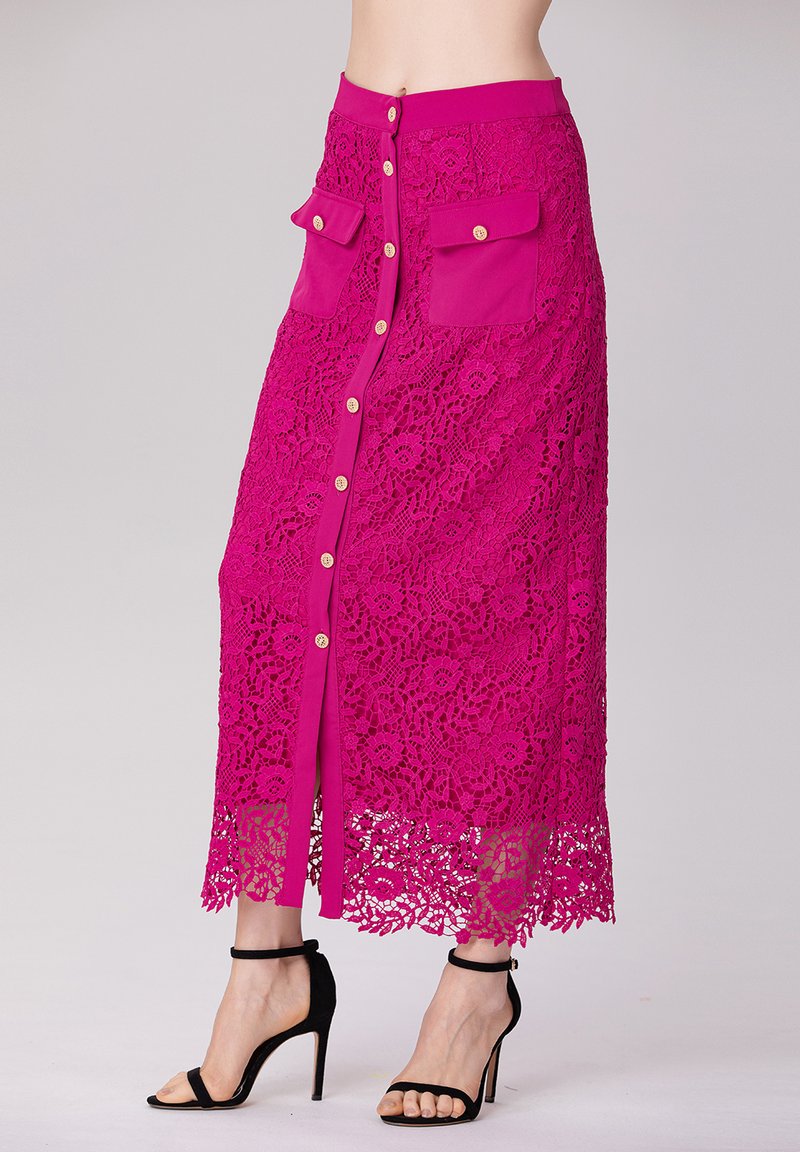 Jupe midi fuchsia avec superposition en dentelle, dotée d'un devant boutonné, de deux poches plaquées et d'un ourlet à volants. Tissu texturé avec un motif floral.