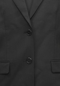 Čierna sako s rázporkom, dvoma prednými vreckami a dvoma lesklými čiernymi gombíkmi. Hladká látka s elegantným, prispôsobeným dizajnom.