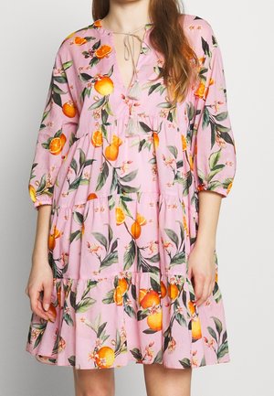 Robe rose à volants avec imprimé de fruits orange et feuilles vertes, manches bouffantes trois-quarts et liens à pompons au col en V.
