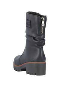 Bota de cuero negra hasta el tobillo con caña arrugada, cremallera lateral plateada, superficie texturizada y un tacón de goma grueso con patrón de relieve.