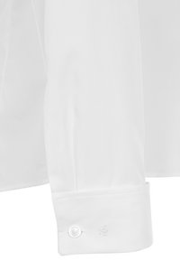 Polsino di camicia bianca in cotone a maniche lunghe con orlo arrotondato, dotato di un singolo bottone e un delicato ricamo vicino al polsino.