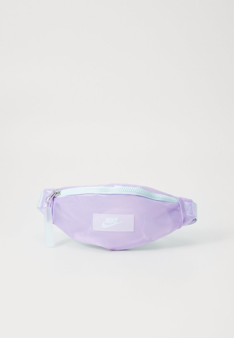Μωβ τσάντα μέσης από γυαλιστερό υλικό με λευκό φερμουάρ και λογότυπο Nike. Διαθέτει λεία υφή και συμπαγές, στρογγυλό σχήμα.