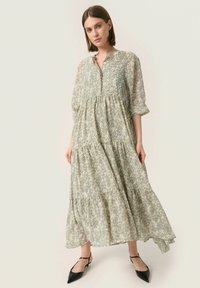 Vestido maxi de tejido verde claro con un patrón floral, que presenta un escote abotonado, mangas tres cuartos y un diseño en capas.