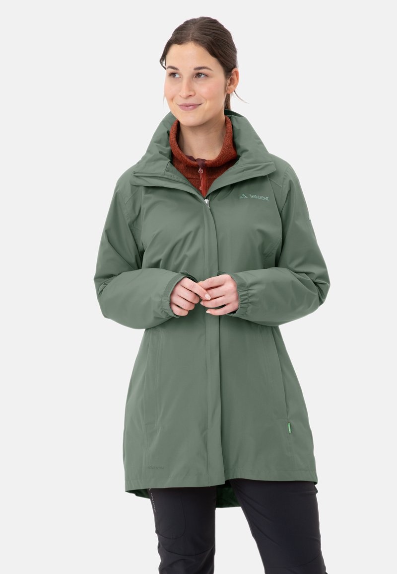 Grüne wasserdichte Jacke mit hohem Kragen, langen Ärmeln und Seitentaschen. Mit durchgehendem Reißverschluss und Logo auf der linken Brust.