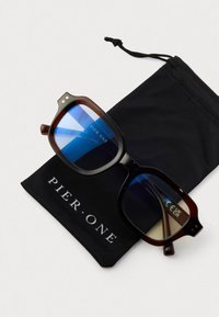 Tortoiseshell obd�ĺžnikové slnečné okuliare s modrými sklami sú položené na čiernom sťahovacom puzdre s nápisom "Pier One."