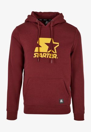 Bordový hoodie vyrobený z bavlnenej zmesi, s veľkým žltým logom so starým, nastaviteľnými šnúrkami a predným kengurím vreckom.