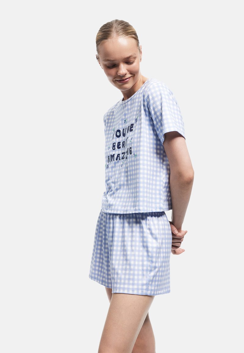 Blau-weißes Karo-Schlafanzug-Set mit kurzen Ärmeln und Shorts. Auf der Vorderseite befindet sich der Drucktext "DU BIST BERRI AMAZING!" Weicher Stoff.