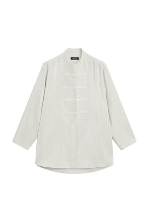 Camicia bianca a maniche lunghe con sottili righe verticali, colletto alla cinese e quattro bottoni visibili sulla patta anteriore.