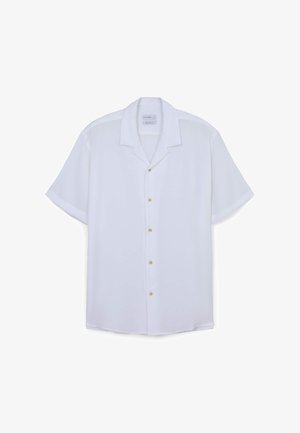 Chemise blanche à manches courtes, en tissu léger, avec un col doux et des boutons dorés le long de la patte de boutonnage.
