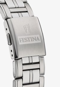 Nerūsējošā tērauda pulksteņa josla ar pulētu un smilšotu virsmu, aprīkota ar salokāmu sprādzi un iegravētu "Festina" logo.